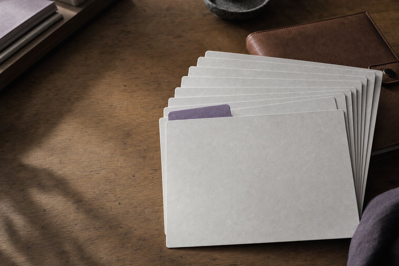 Juego de separadores de fichas en blanco desplegados en abanico sobre una mesa.