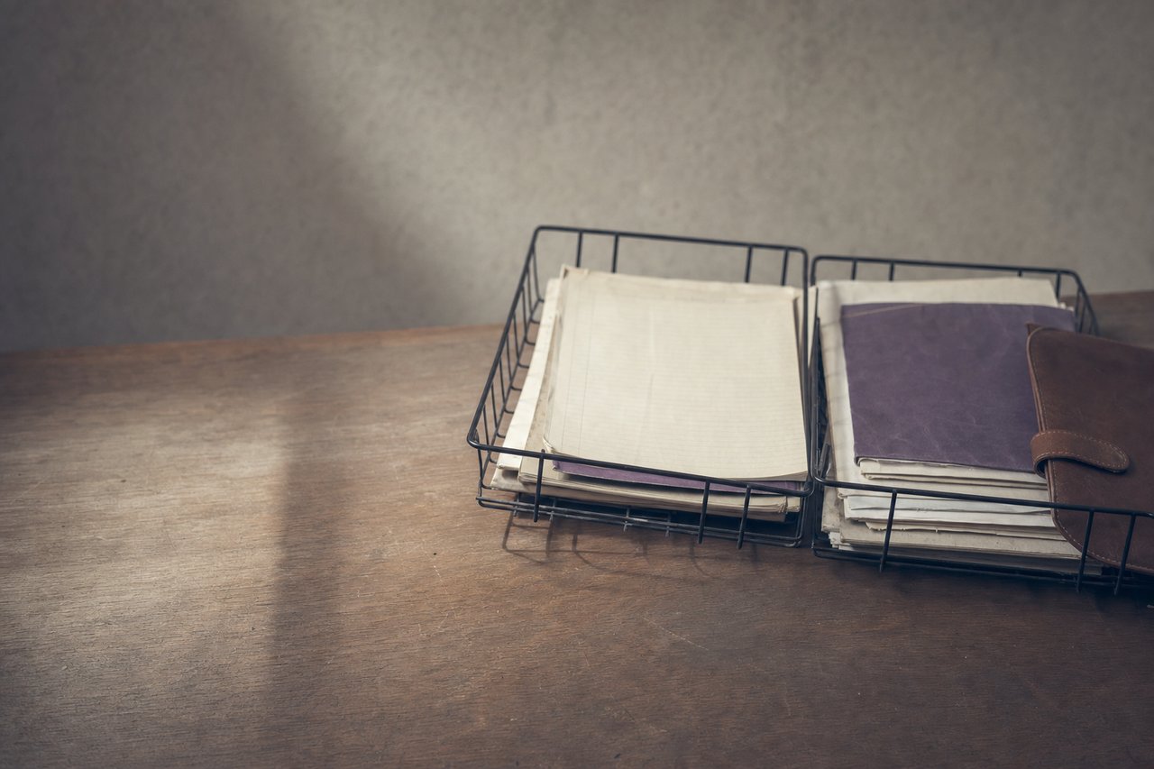 Dos juegos de material de oficina separados por una línea de cinta adhesiva sobre una mesa compartida.