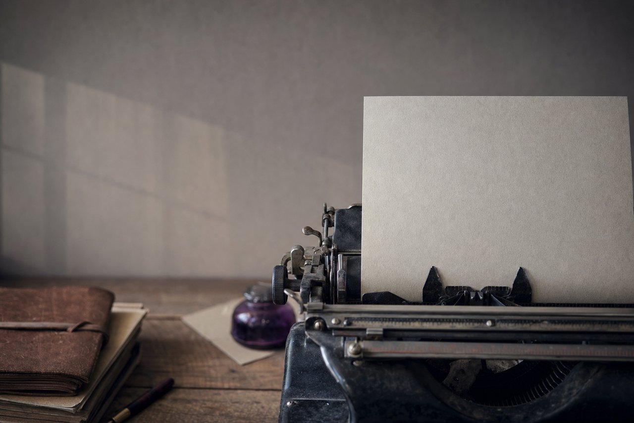 Rodillo de una máquina de escribir con una hoja de papel en blanco introducida a medias.